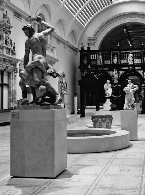 The image depicts an interior space resembling a historic museum or gallery with classical sculptures displayed on pedestals. In the foreground, a detailed marble statue of a male figure stands promin